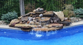 Freeform-pool-natural-waterfall-water-feature-cantiliever-coping-washed-tumbled-stone